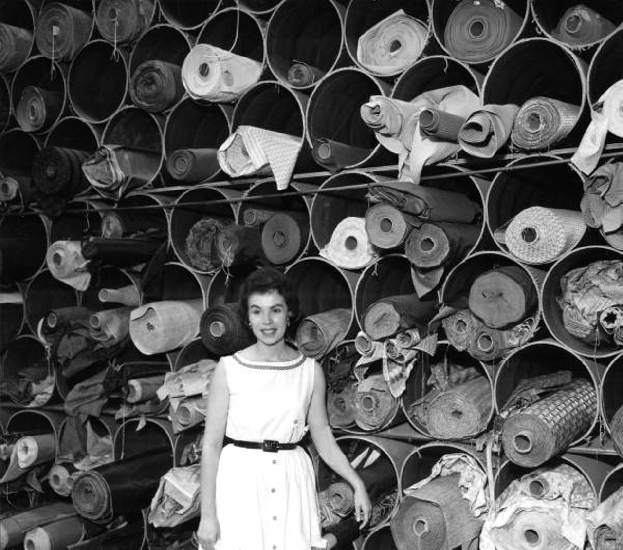 Mercedes Ficarrotta stands in front of upholstery fabrics - Tampa, Florida (1960).