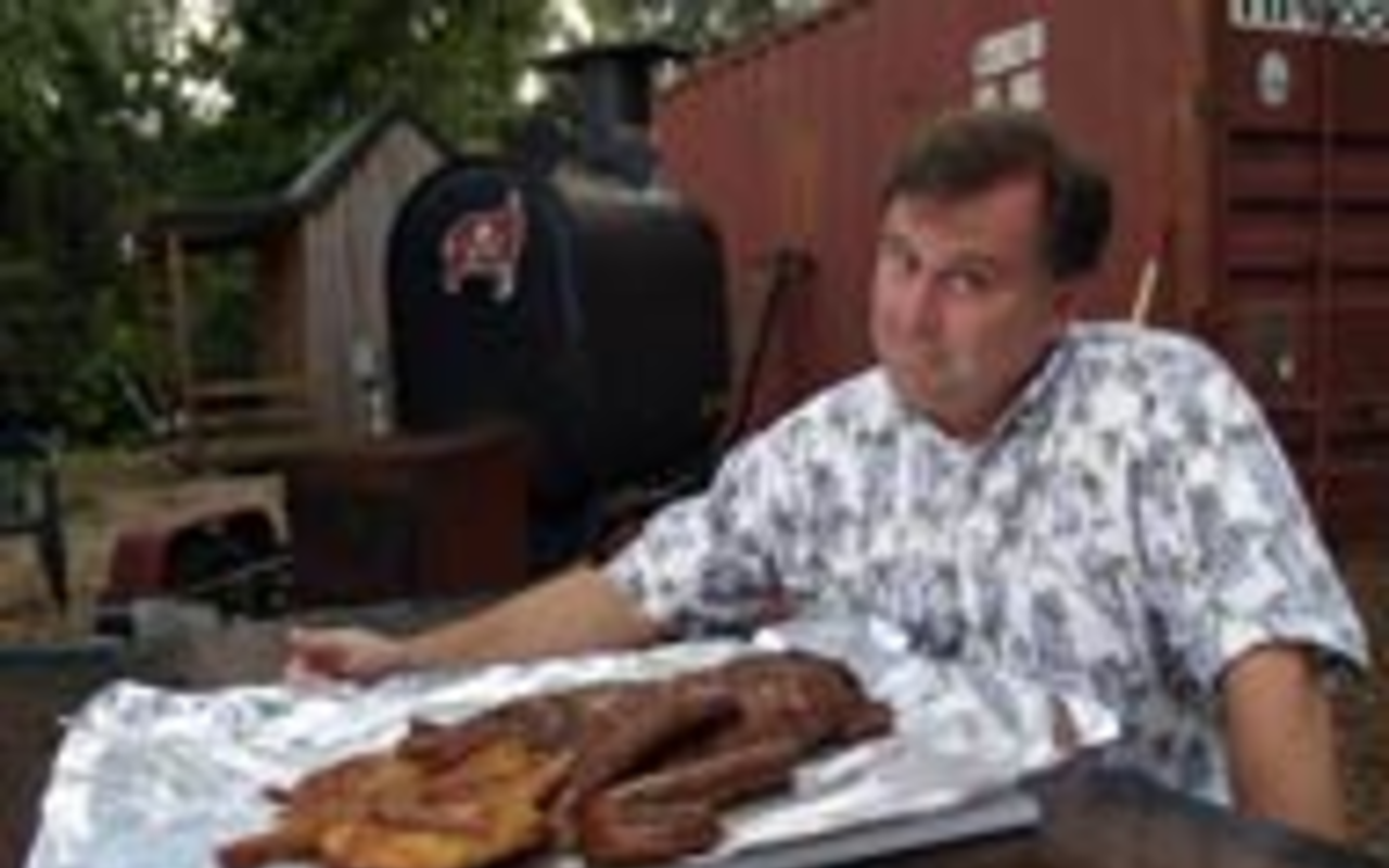BOB KNOWS BBQ: Barbecue scholar Bob Rauchmiller 
    displays some of his achievements.