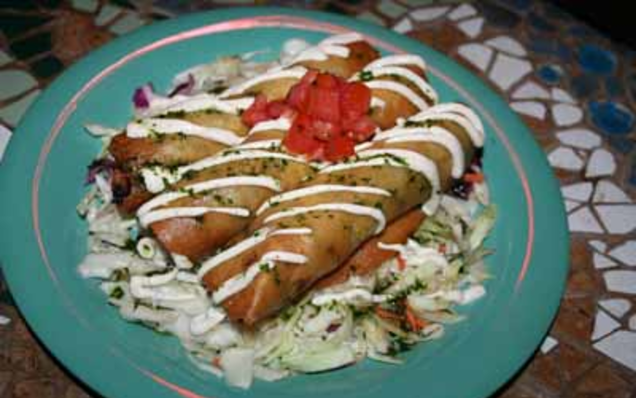 HOW 'BOUT THEM FLAUTAS? Pork flautas on a bed of marinated cabbage and covered with Zurritos' special sour cream and cilantro oil.